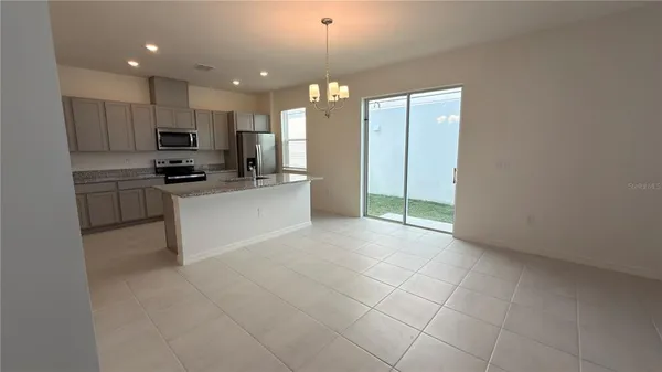 a kitchen with kitchen island granite countertop a sink cabinets and stainless steel appliances