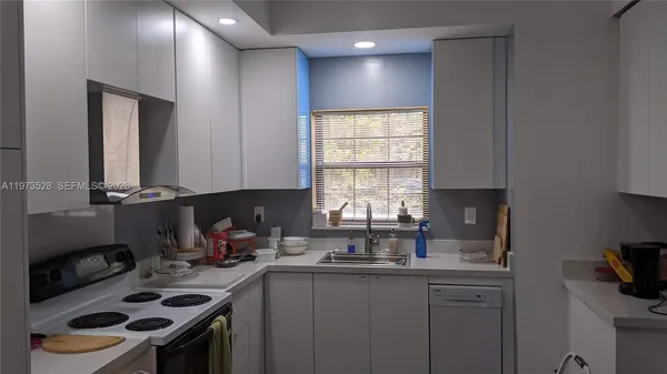 a bedroom with a bed next to a window with a chair