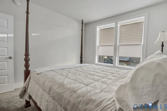 a bedroom with a bed and a large window