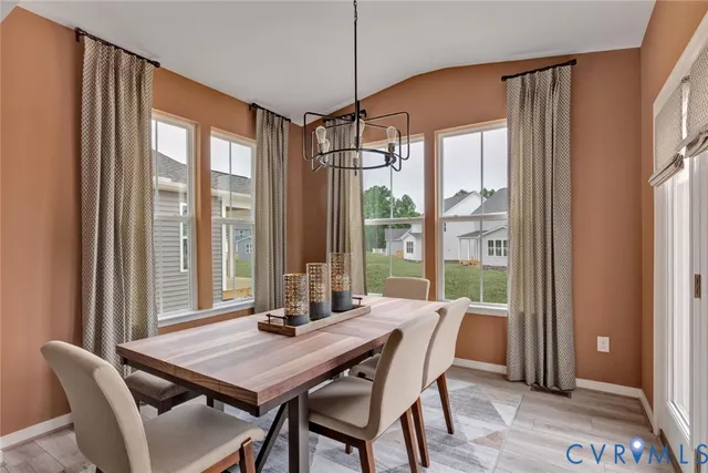 a dining room with stainless steel appliances granite countertop a kitchen island a stove and a wooden floors