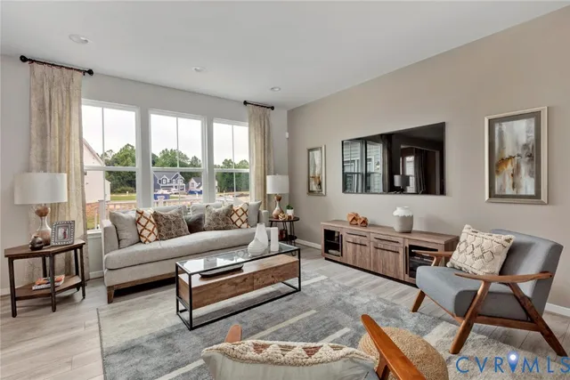 a living room with furniture a flat screen tv and kitchen view