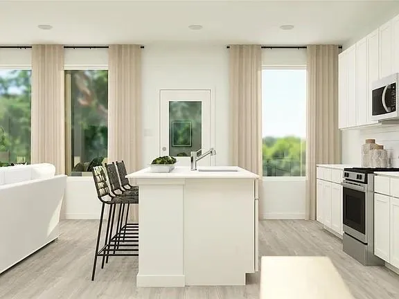 a kitchen with stainless steel appliances granite countertop a white cabinets and a stove top oven