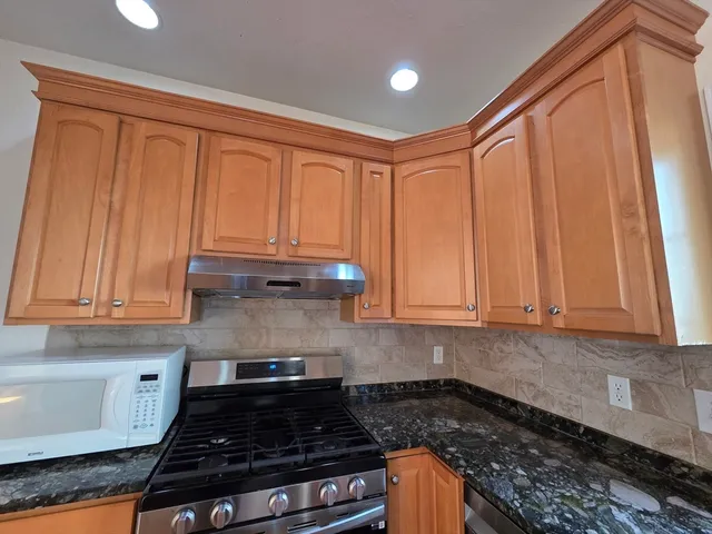 a kitchen with stainless steel appliances granite countertop a refrigerator