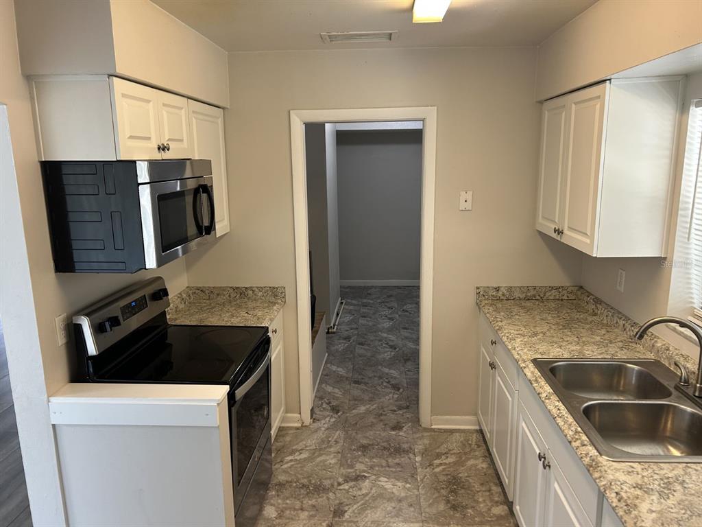 1241 Pilgrim Road Spring Hill, FL 34606 - Photo 9 of 28 a kitchen that has a sink and a stove in it