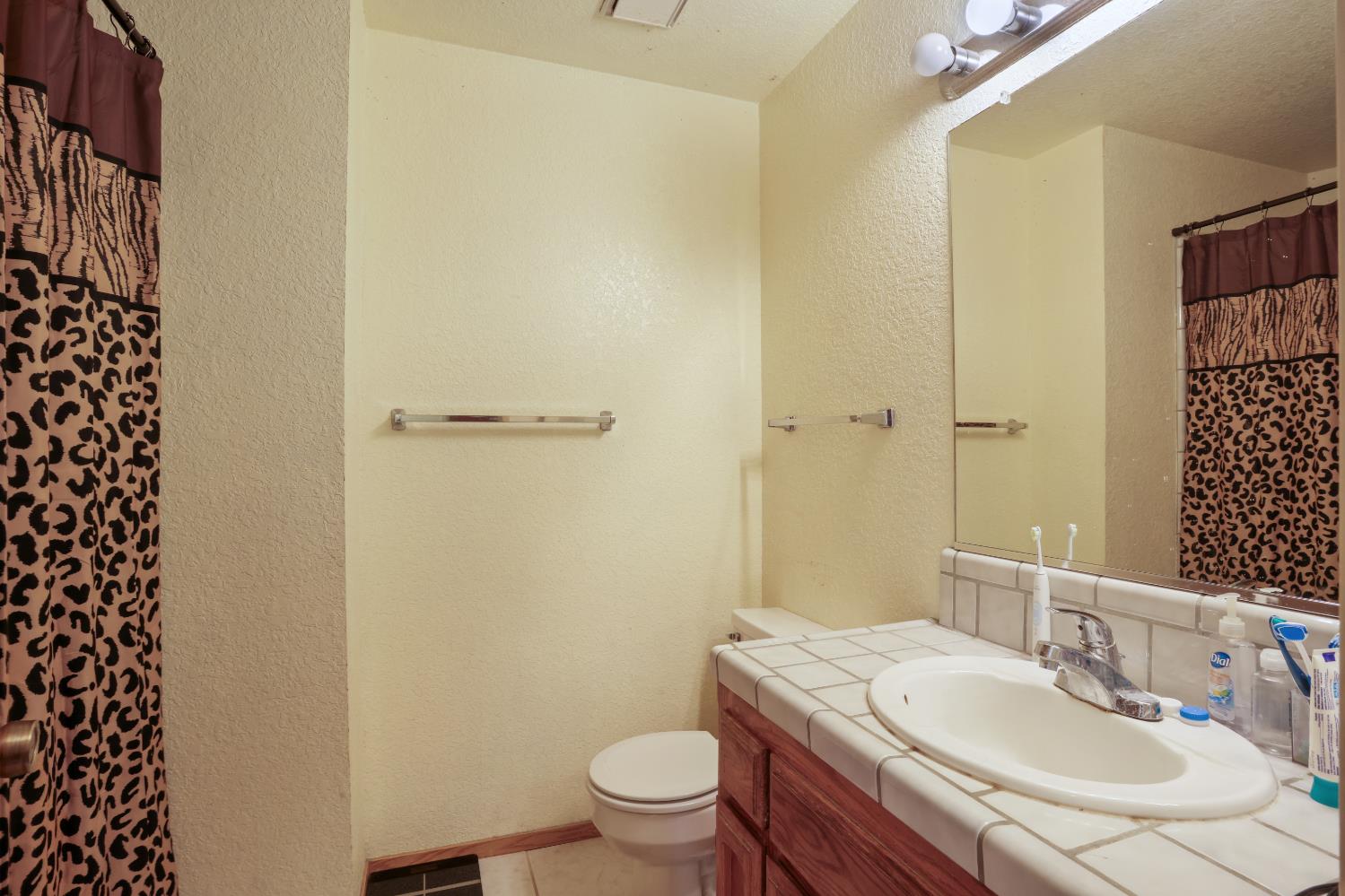2008 Sheldon Drive Modesto, CA 95350 - Photo 28 of 39 a bathroom with a granite countertop sink toilet and shower