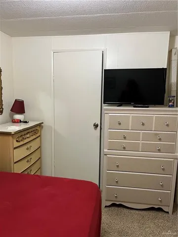 a view of a bedroom with a flat tv screen and a dresser