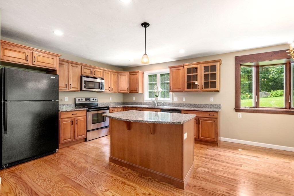 8 Reed Lane, Unit 8 Littleton, MA 01460 - Photo 11 of 37 a kitchen with stainless steel appliances granite countertop a refrigerator a stove top oven a sink and dishwasher