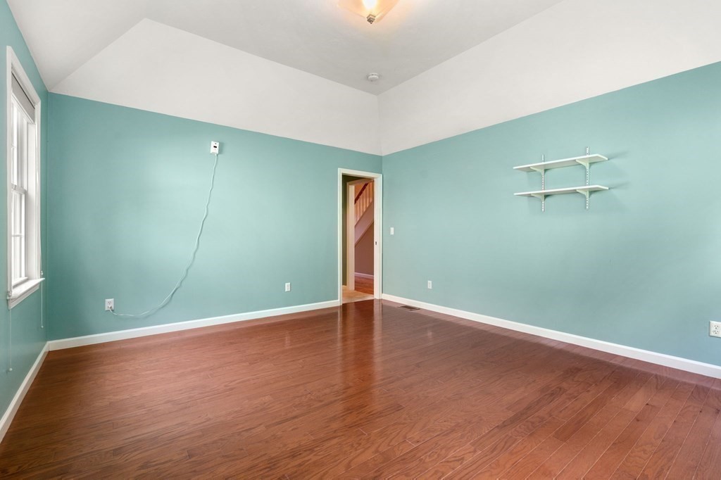 8 Reed Lane, Unit 8 Littleton, MA 01460 - Photo 20 of 37 an empty room with wooden floor and windows