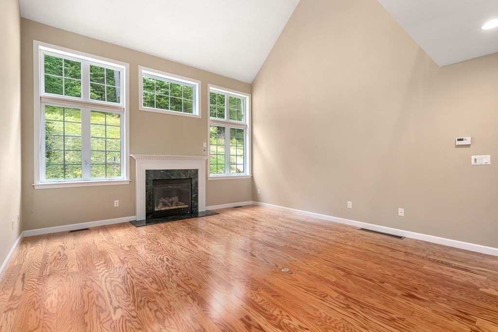 8 Reed Lane, Unit 8 Littleton, MA 01460 - Photo 9 of 37 a view of empty room with wooden floor and fireplace