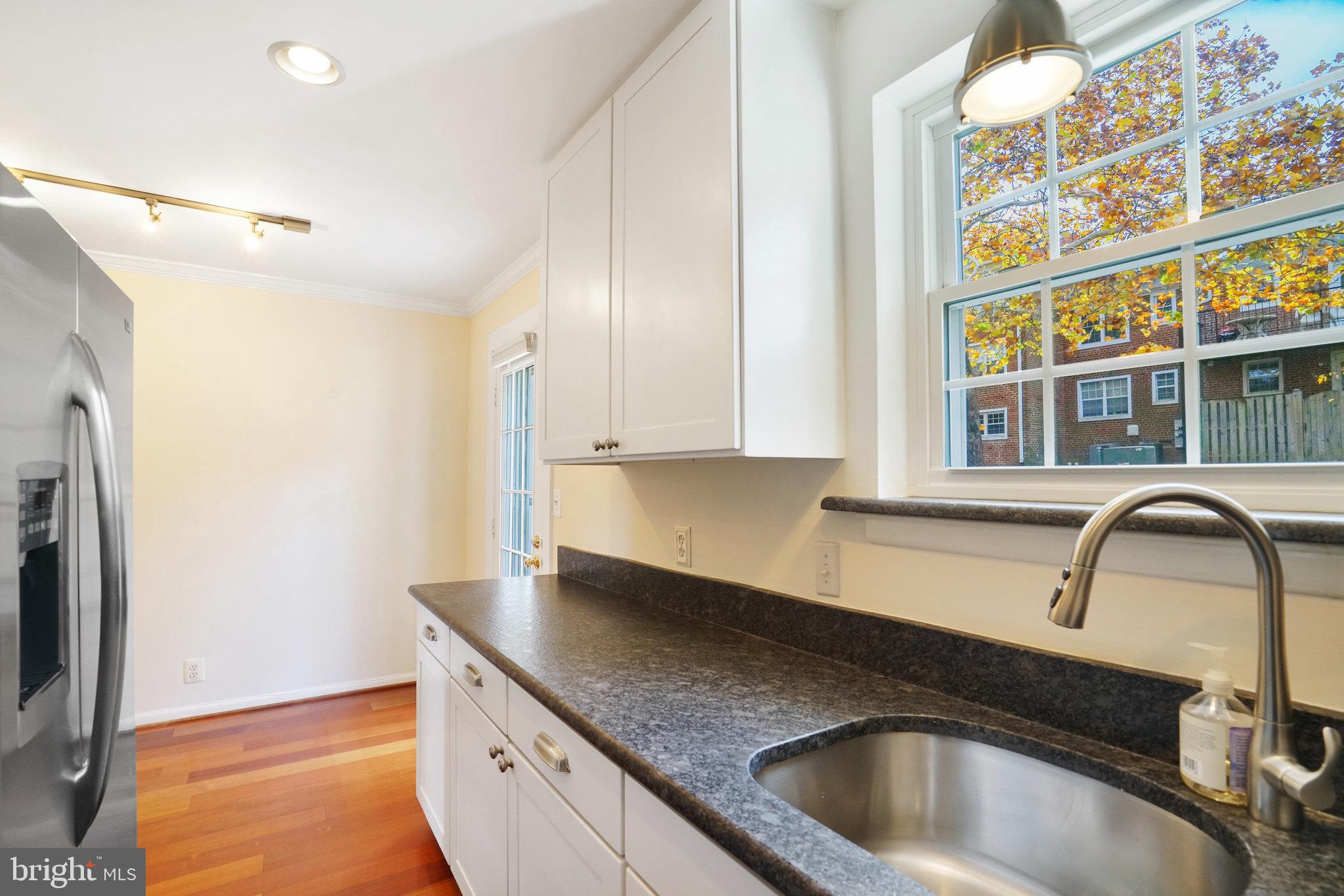 4614 28th Road South, Unit B Arlington, VA 22206 - Photo 13 of 27 a kitchen with stainless steel appliances granite countertop a sink and a granite counter tops with a wooden floor