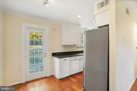 a kitchen with granite countertop white cabinets and white appliances