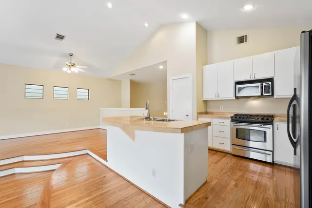 a kitchen with stainless steel appliances granite countertop a refrigerator a stove a sink and a microwave