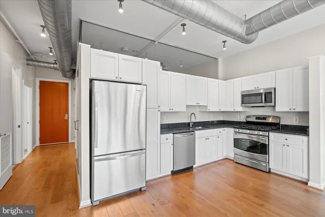 a kitchen with stainless steel appliances a refrigerator sink and microwave