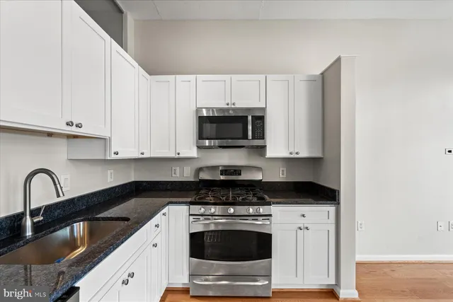 a kitchen with granite countertop a stove and a sink