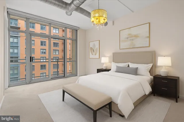 a spacious bedroom with a bed and a large window