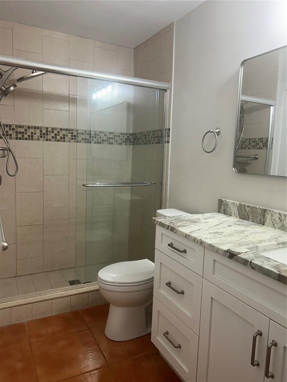 7006 Midnight Pass Road, Unit 1 Sarasota, FL 34242 - Photo 9 of 12 a bathroom with a granite countertop sink toilet and shower