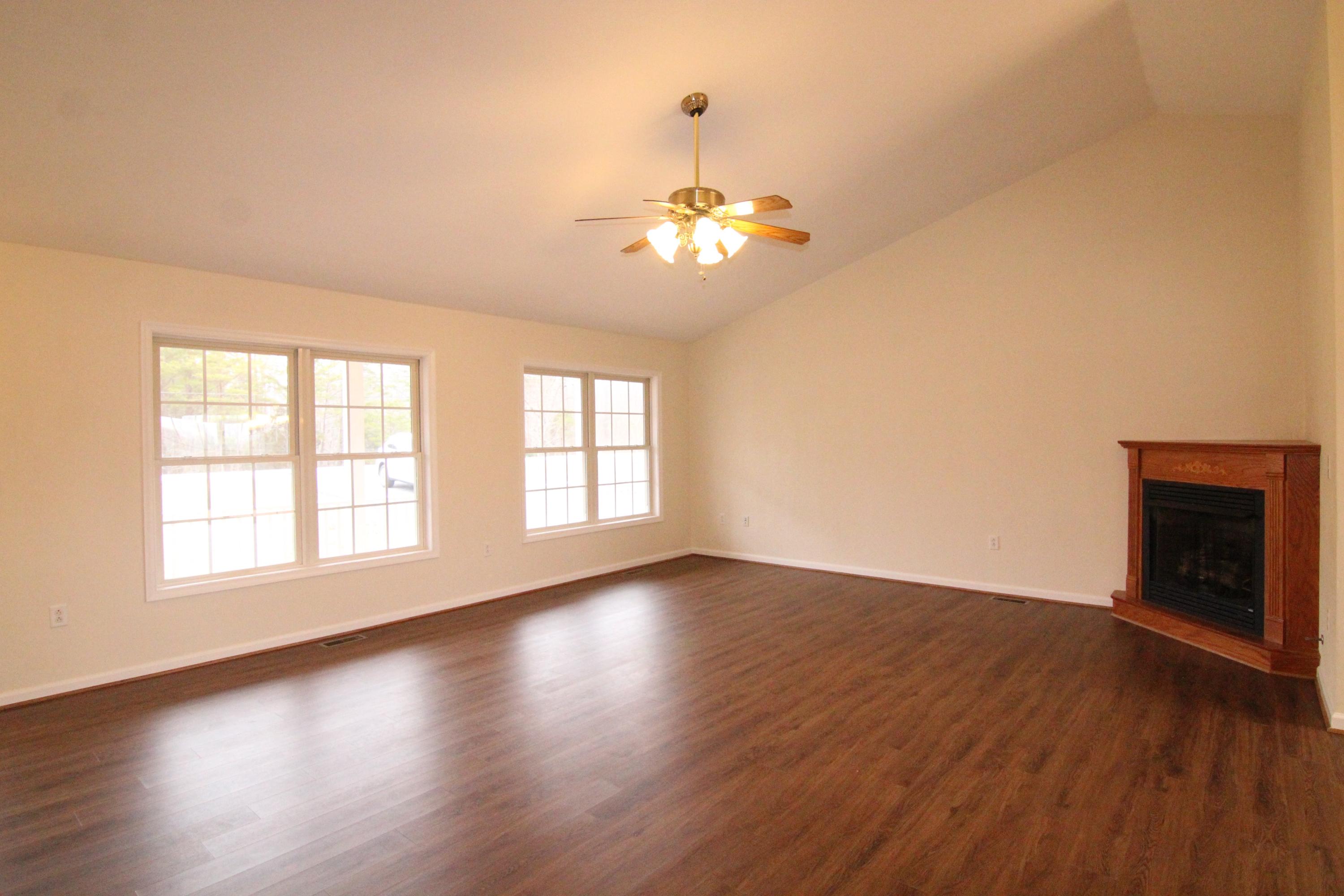 5949 Hardy Road Hardy, VA 24101 - Photo 9 of 38 an empty room with wooden floor chandelier fan and windows