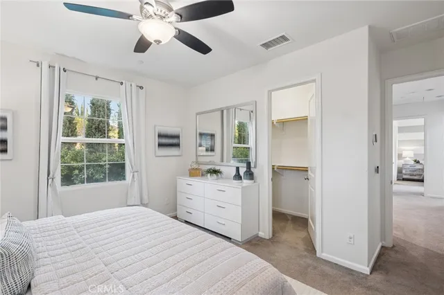 a bedroom with a bed and a chandelier fan