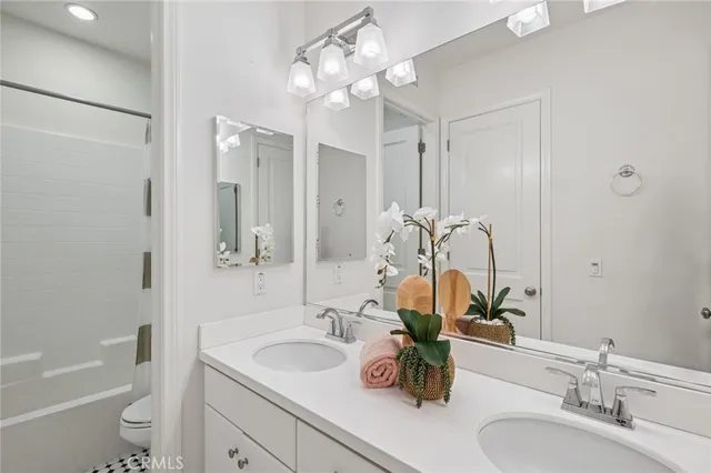 a bathroom with a sink a toilet and a large mirror