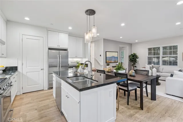 a kitchen with granite countertop kitchen island stainless steel appliances a table and chairs