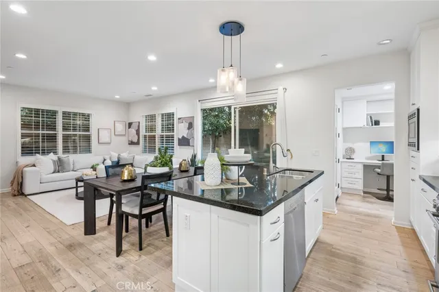 a kitchen with granite countertop kitchen island stainless steel appliances a sink and living room view