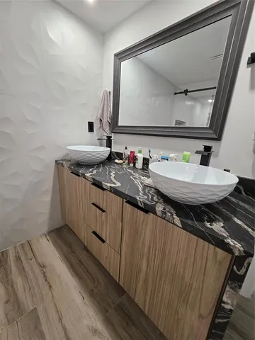 a bathroom with a granite countertop sink a mirror and vanity