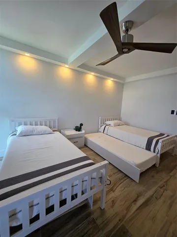 a bedroom with two beds and a ceiling fan