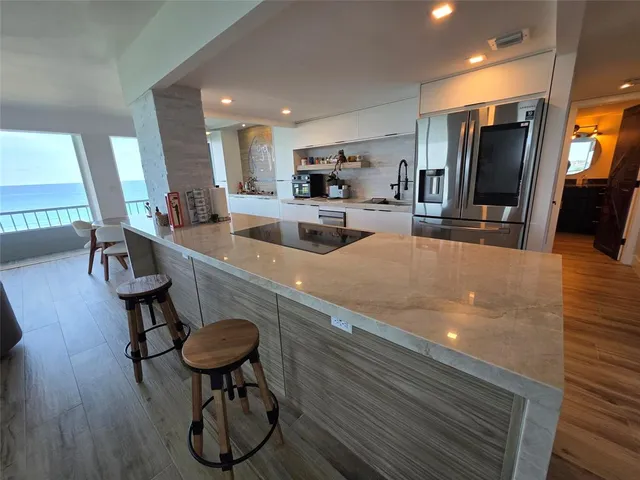 a kitchen with stainless steel appliances granite countertop a sink a stove and a refrigerator