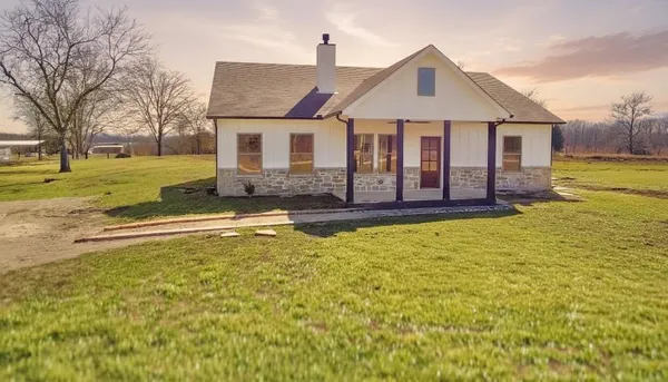 a front view of a house with yard and green space