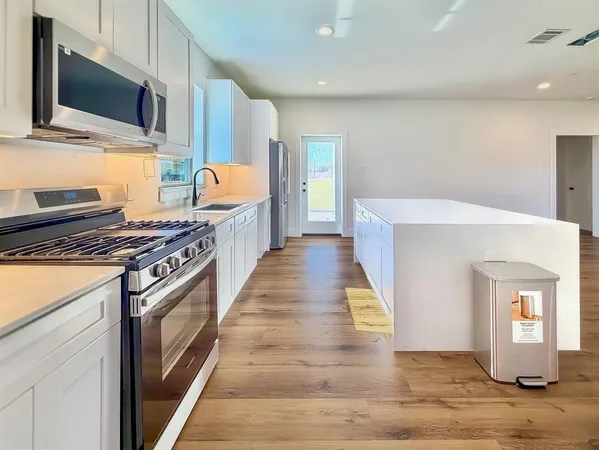 a kitchen with stainless steel appliances granite countertop a stove and a microwave
