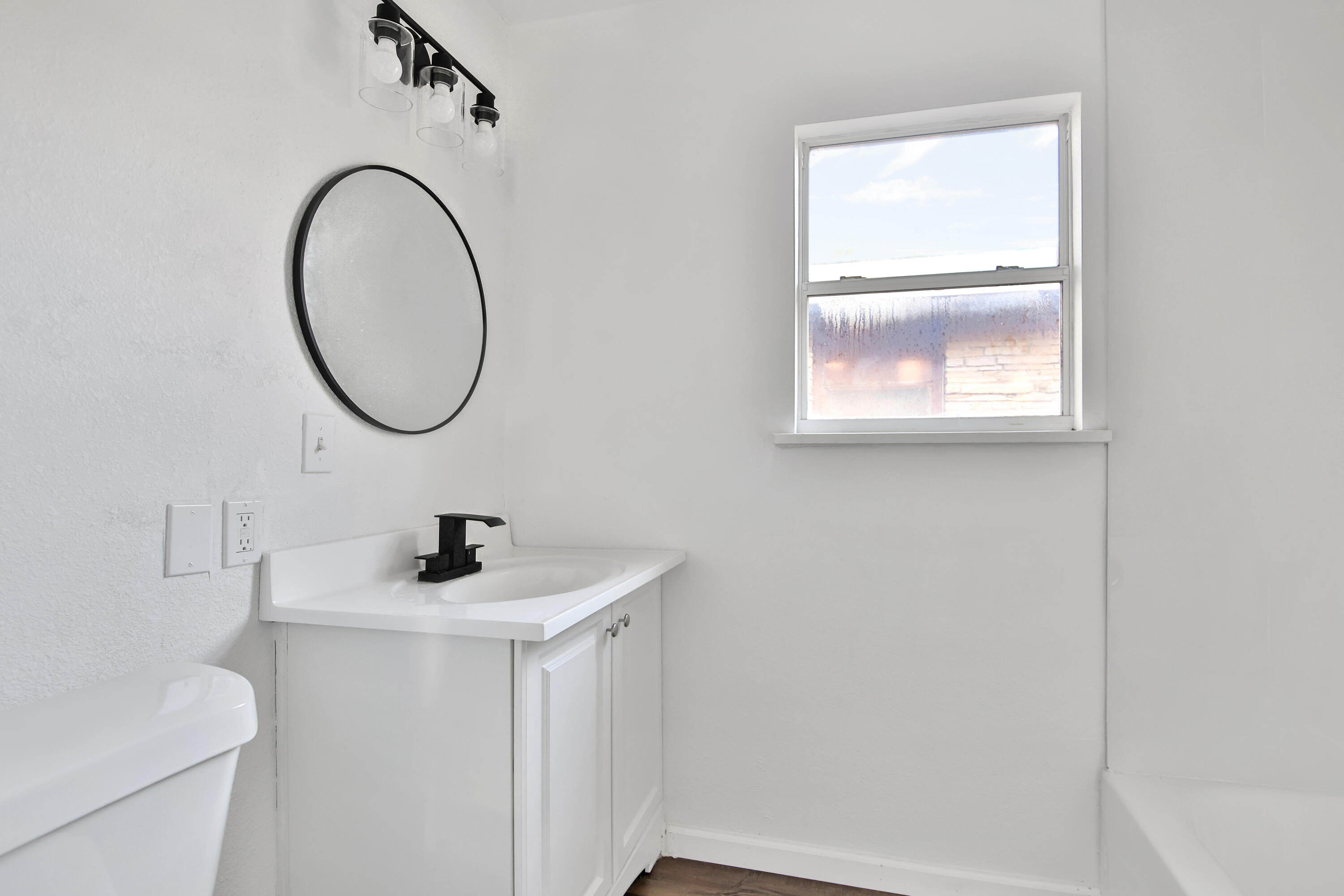 2004 31st Street Lubbock, TX 79411 - Photo 22 of 24 a bathroom with a sink a toilet and a mirror