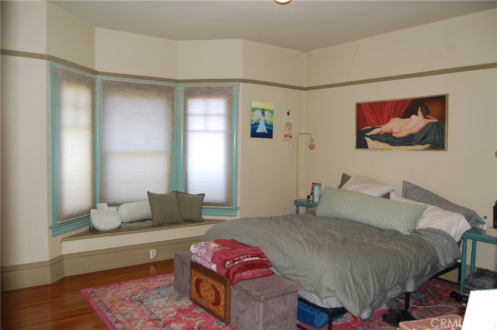 4160 Chestnut Street Riverside, CA 92501 - Photo 15 of 39 a bedroom with a bed and wooden floor