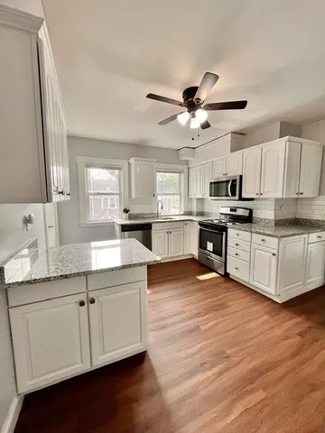 a kitchen with stainless steel appliances a sink a stove a refrigerator cabinets and a center island