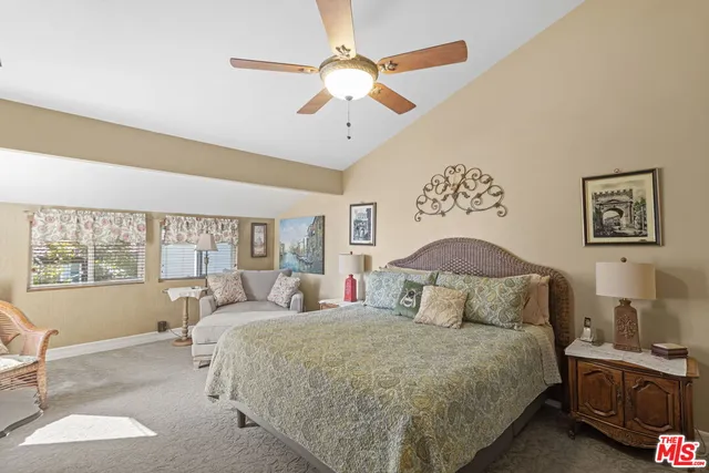 a bedroom with a large bed and a chandelier