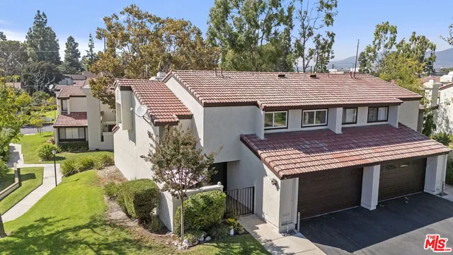 a front view of a house with a garden and plants