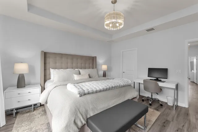 a bedroom with a bed and a chandelier