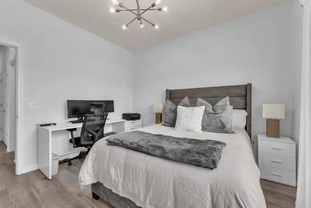 a bedroom with a large bed and a chandelier