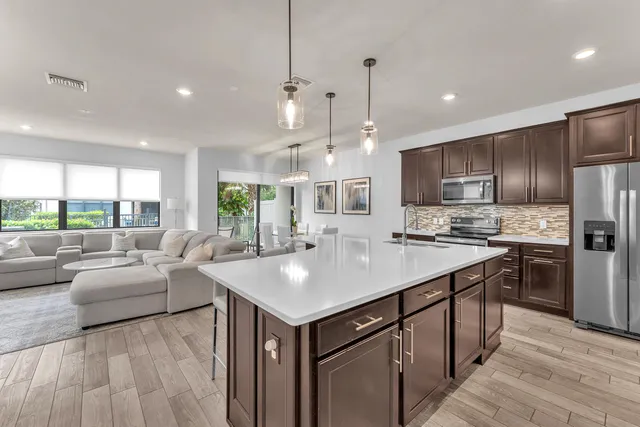 a kitchen with counter top space a sink stainless steel appliances and windows