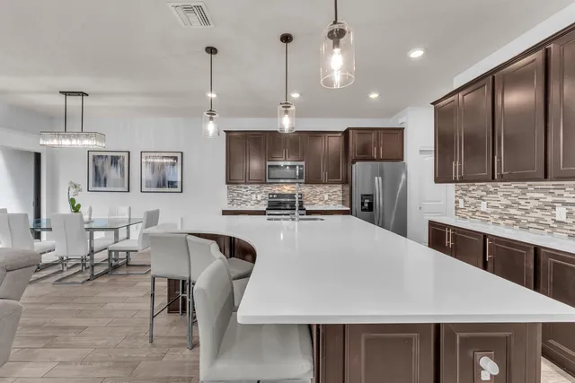 a large kitchen with kitchen island a table and chairs