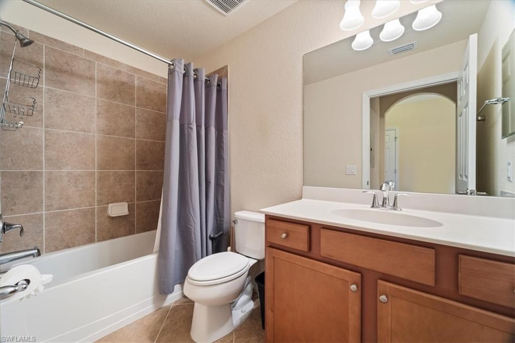 9830 Giaveno Circle, Unit 1622 Naples, FL 34113 - Photo 14 of 43 a bathroom with a sink a toilet a mirror a bathtub and shower