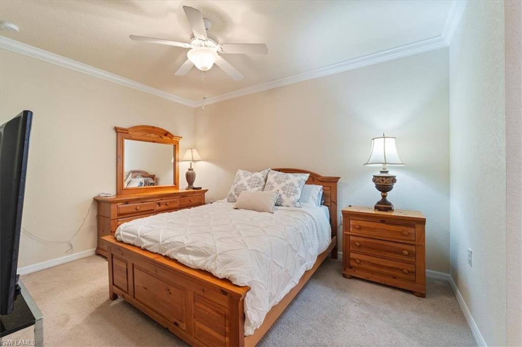 9830 Giaveno Circle, Unit 1622 Naples, FL 34113 - Photo 15 of 43 a bedroom with a bed and a chandelier