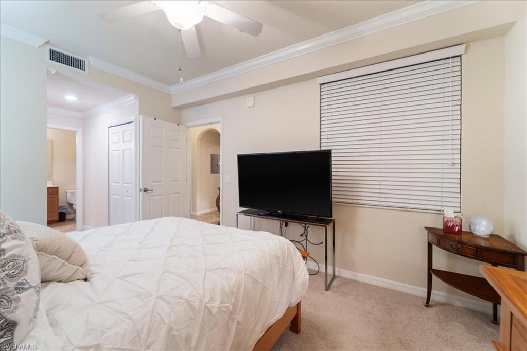 9830 Giaveno Circle, Unit 1622 Naples, FL 34113 - Photo 16 of 43 a bedroom with a bed and a flat screen tv