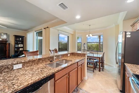 a kitchen with granite countertop a sink and chairs