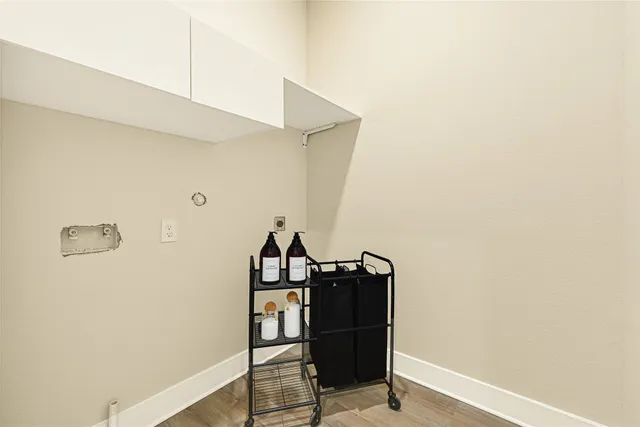 a view of a hallway with wooden floor and cabinet