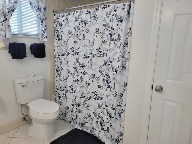 a bathroom with a toilet and a shower curtain