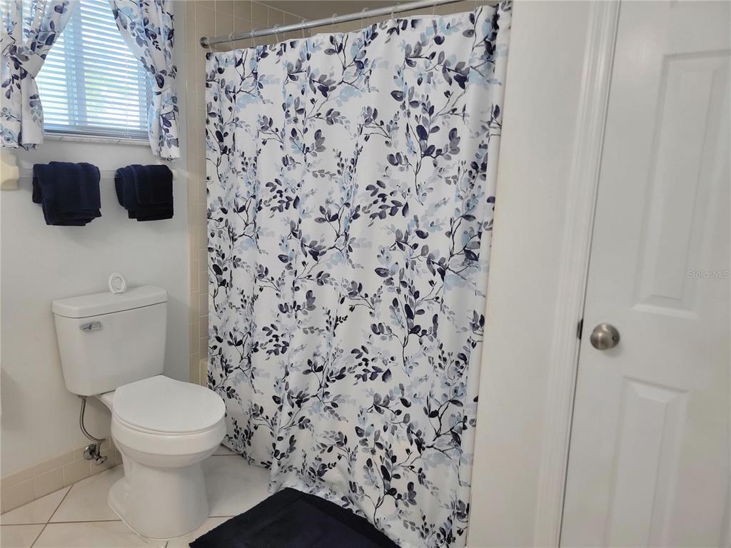 10967 Southwest 65th Avenue Ocala, FL 34476 - Photo 12 of 16 a bathroom with a toilet and a shower curtain