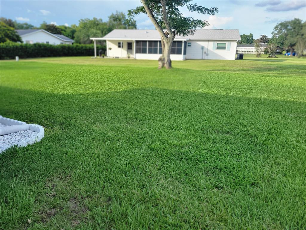 10967 Southwest 65th Avenue Ocala, FL 34476 - Photo 15 of 16 a white house with a big yard and large trees