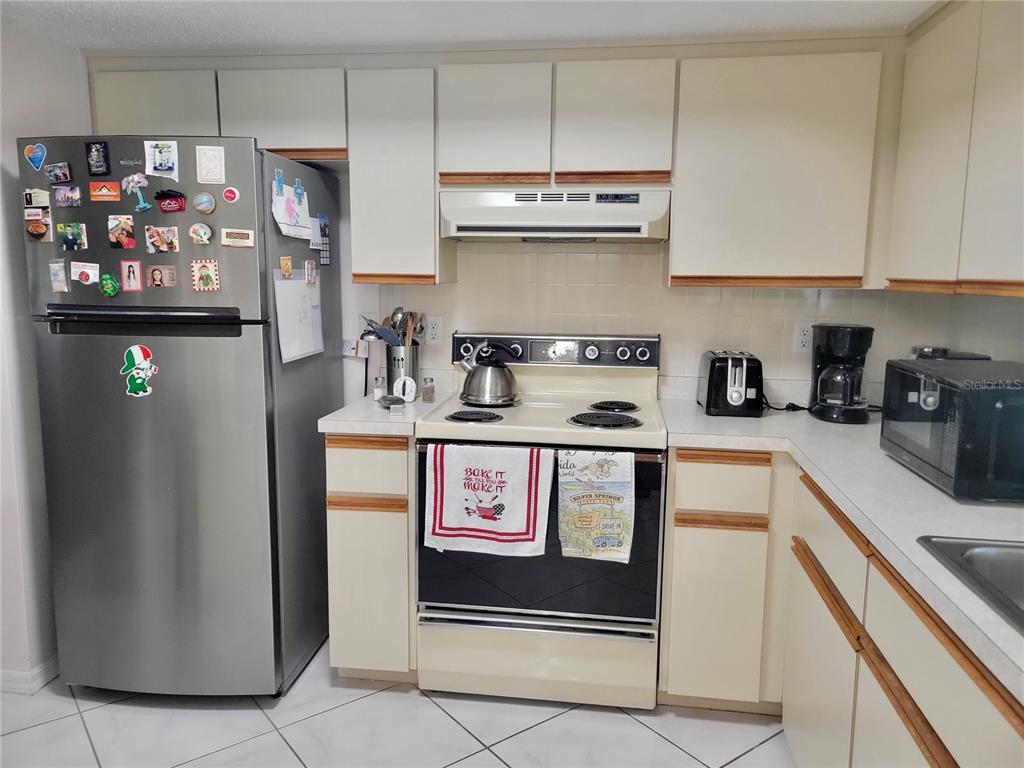 10967 Southwest 65th Avenue Ocala, FL 34476 - Photo 3 of 16 a kitchen with stainless steel appliances granite countertop a refrigerator and a stove top oven
