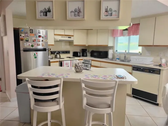 a kitchen with stainless steel appliances granite countertop a sink and a refrigerator