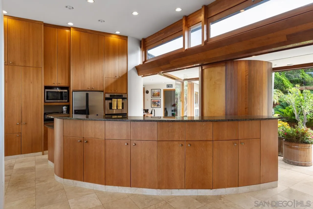 1720 Torrey Pines Road La Jolla, CA 92037 - Photo 13 of 43 a kitchen with stainless steel appliances wooden cabinets and a refrigerator